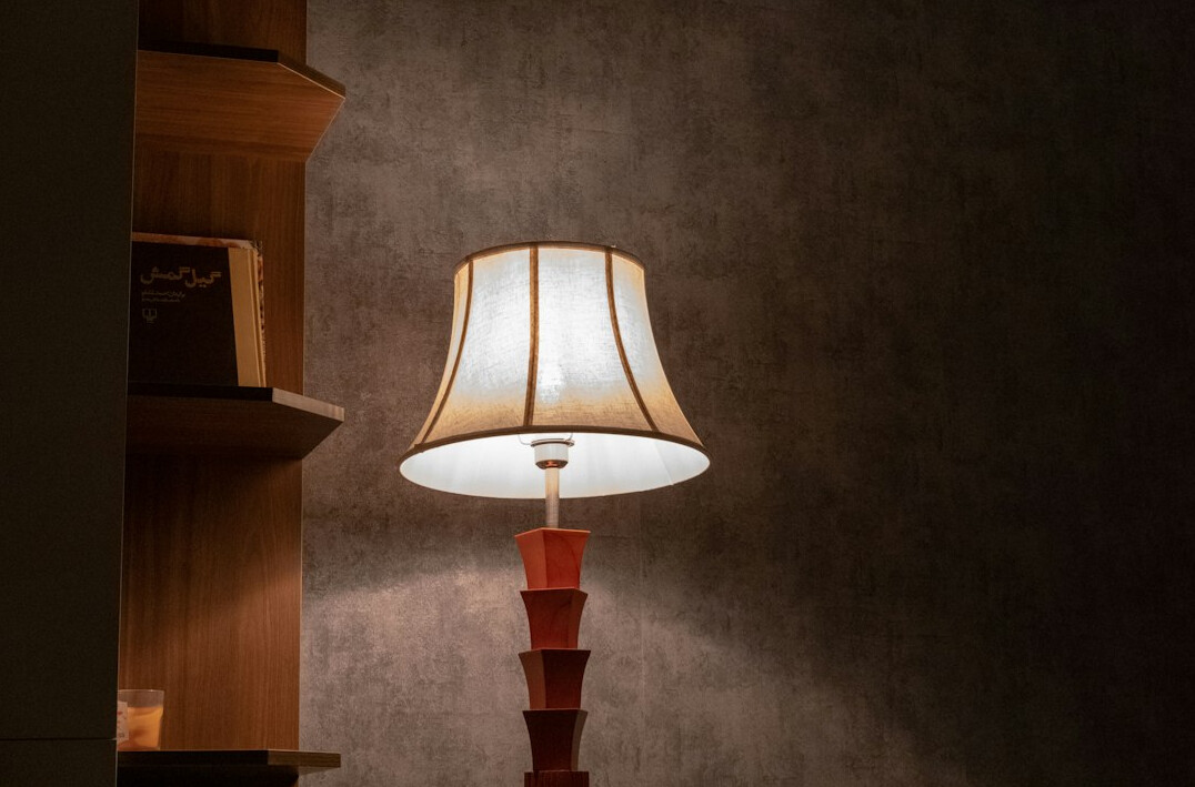 Atmospheric old library with tall wooden bookshelves and warm lamp light