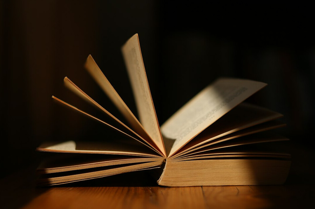 Open book with pages fanned out on a table